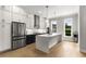 Modern kitchen with stainless steel appliances, white cabinets, large island, and hardwood floors at 2125 Parkside Ln, Roswell, GA 30076