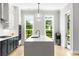 Modern kitchen features large island with views from dual windows, stainless appliances, and pendant lighting at 2125 Parkside Ln, Roswell, GA 30076