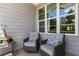 Relaxing outdoor seating with comfortable cushioned chairs, a small side table, and a view through a large window at 2125 Parkside Ln, Roswell, GA 30076