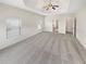 Spacious bedroom featuring a tray ceiling, ceiling fan, carpet flooring and two windows at 622 Madison Park Dr, Grayson, GA 30017