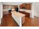 Spacious kitchen featuring a large island, granite countertops, and dark wood cabinets at 622 Madison Park Dr, Grayson, GA 30017