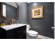 Charming powder room with a unique vanity, framed artwork, and sophisticated dark grey wall at 1379 Cambridge Ne Ct, Brookhaven, GA 30319