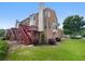 Backyard view with a wood deck, green grass, and mature landscaping at 2231 Mill Garden Pl, Buford, GA 30519