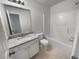 Bright bathroom featuring a granite-topped vanity, toilet, and a shower-tub combination with a white surround at 2231 Mill Garden Pl, Buford, GA 30519