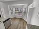 Bright breakfast nook featuring wood floors, a bay window, and white cabinets for storage at 2231 Mill Garden Pl, Buford, GA 30519