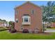Rear view of all-brick home with manicured landscaping, bay window and lush green lawn at 2231 Mill Garden Pl, Buford, GA 30519
