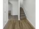 Hallway with wood-look flooring transitions to carpet leading to a staircase and lower level at 2231 Mill Garden Pl, Buford, GA 30519