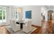 Dining room with modern chandelier, glass table, hardwood floors, and large windows at 3401 Stillhouse Se Rd, Atlanta, GA 30339