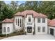 Elegant two-story home showcasing a beautiful stucco facade, arched windows, and a terracotta tiled roof at 3401 Stillhouse Se Rd, Atlanta, GA 30339
