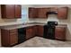 Well-equipped kitchen with dark wooden cabinets, essential appliances, and tiled floors at 515 Brady Dr, Villa Rica, GA 30180
