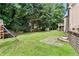 Grassy backyard features a stone retaining wall, patio area, and play set at 5807 Brookstone Nw Walk, Acworth, GA 30101