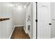 Hallway view of powder room with dark hardwood floors, coat rack, and white-painted door at 5807 Brookstone Nw Walk, Acworth, GA 30101