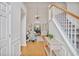 Open foyer with staircase, chandelier, light wood floors, and views to living spaces at 845 Melbourne Trl, Alpharetta, GA 30009