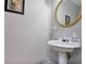 Charming powder room features gray walls, a round mirror, and white pedestal sink at 845 Melbourne Trl, Alpharetta, GA 30009