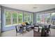 Bright sunroom with wicker furniture, large windows, and view of the surrounding greenery at 845 Melbourne Trl, Alpharetta, GA 30009