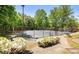 Community tennis court surrounded by lush greenery and flowers at 845 Melbourne Trl, Alpharetta, GA 30009