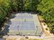 Aerial view of the community tennis courts surrounded by mature trees at 845 Melbourne Trl, Alpharetta, GA 30009