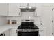 Well-equipped kitchen with a sleek stovetop, subway tile backsplash, and white cabinetry at 2135 Huntington Dr, Loganville, GA 30052