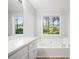 Bathroom features a soaking tub, white cabinets, and a large window at 94 Park W Ave, Dallas, GA 30157
