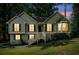 Charming split-level home with green siding, black shutters, and a inviting front entrance, with sunset backdrop at 94 Park W Ave, Dallas, GA 30157