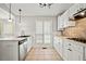 Bright kitchen features white cabinetry, stainless steel appliances, and tile flooring at 94 Park W Ave, Dallas, GA 30157