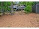 Exterior backyard view of a gray home with deck, stairs, and wooded surroundings at 10775 Shallowford Rd, Roswell, GA 30075
