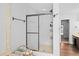 Bathroom with glass-door shower, towel rack, marble surround and vanity storage at 10775 Shallowford Rd, Roswell, GA 30075