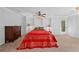 Bright bedroom with a red quilt-covered bed, ceiling fan, and a beautiful dark wood dresser at 10775 Shallowford Rd, Roswell, GA 30075