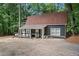 Charming home boasts a front porch and gravel driveway, nestled among mature trees at 10775 Shallowford Rd, Roswell, GA 30075