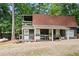 Charming home boasts a front porch and gravel driveway, nestled among mature trees at 10775 Shallowford Rd, Roswell, GA 30075