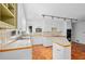 Sunlit kitchen boasting terracotta tile floor, white cabinets, tile countertops, and modern lighting at 10775 Shallowford Rd, Roswell, GA 30075
