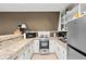 This kitchenette has stainless steel appliances, light countertops, and shelving above the counter at 10775 Shallowford Rd, Roswell, GA 30075