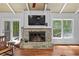Living room featuring a stone fireplace, large windows, and hardwood floors at 10775 Shallowford Rd, Roswell, GA 30075