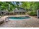 A lovely pool in the backyard, surrounded by stone, with a seating area to enjoy the beauty of nature at 10775 Shallowford Rd, Roswell, GA 30075