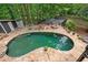 Backyard oasis featuring pool, stone patio, fire pit, and wooded surroundings at 10775 Shallowford Rd, Roswell, GA 30075