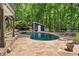 Beautiful pool surrounded by a stone patio and lush greenery, creating a private backyard oasis at 10775 Shallowford Rd, Roswell, GA 30075