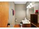 Cozy powder room featuring decorative accents and natural lighting, with a sink vanity and toilet at 10775 Shallowford Rd, Roswell, GA 30075