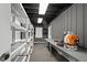 Spacious storage room features shelving, work table and blower, providing organization and functionality at 10775 Shallowford Rd, Roswell, GA 30075