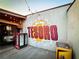 Outdoor patio with a Coca-Cola fridge, mural of 'El Tesoro', and decorative string lights at 34 Montgomery Se St, Atlanta, GA 30317