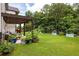 Expansive backyard featuring a pergola, patio furniture, and manicured lawn with garden beds at 374 Heritage, Woodstock, GA 30188