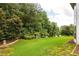 Spacious backyard with lush lawn, a wooden fence, and mature trees, offering privacy at 374 Heritage, Woodstock, GA 30188