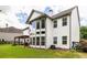 Rear exterior showing a spacious backyard, pergola, large windows, and lush landscaping at 374 Heritage, Woodstock, GA 30188