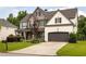 Beautiful two-story home with a combination of stone and brick, lush landscaping, and attached two-car garage at 374 Heritage, Woodstock, GA 30188
