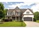Charming two-story home featuring a stone and brick facade, well-manicured lawn, and an attached two-car garage at 374 Heritage, Woodstock, GA 30188