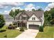 Beautiful two-story home featuring a combination of stone and brick, well-manicured lawn, and an attached two-car garage at 374 Heritage, Woodstock, GA 30188