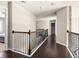 Open hallway with dark hardwood floors, iron railings, and a stone-accented column at 374 Heritage, Woodstock, GA 30188