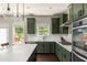 Modern kitchen features stylish green cabinets, stone countertops, stainless appliances and large island at 374 Heritage, Woodstock, GA 30188