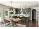 Eat-in kitchen features stylish green cabinets, stone countertops, stainless appliances and modern pendant lighting at 374 Heritage, Woodstock, GA 30188