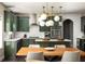 Eat-in kitchen features stylish green cabinets, stone countertops, stainless appliances and modern pendant lighting at 374 Heritage, Woodstock, GA 30188