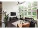 Bright living room with a stone fireplace, hardwood floors, and large windows offering plenty of natural light at 374 Heritage, Woodstock, GA 30188